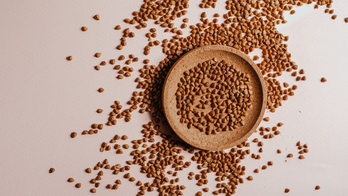 Grains et farine de sarrasin bio dans un bol en céramique, symbole de la crêperie bio et circuits courts